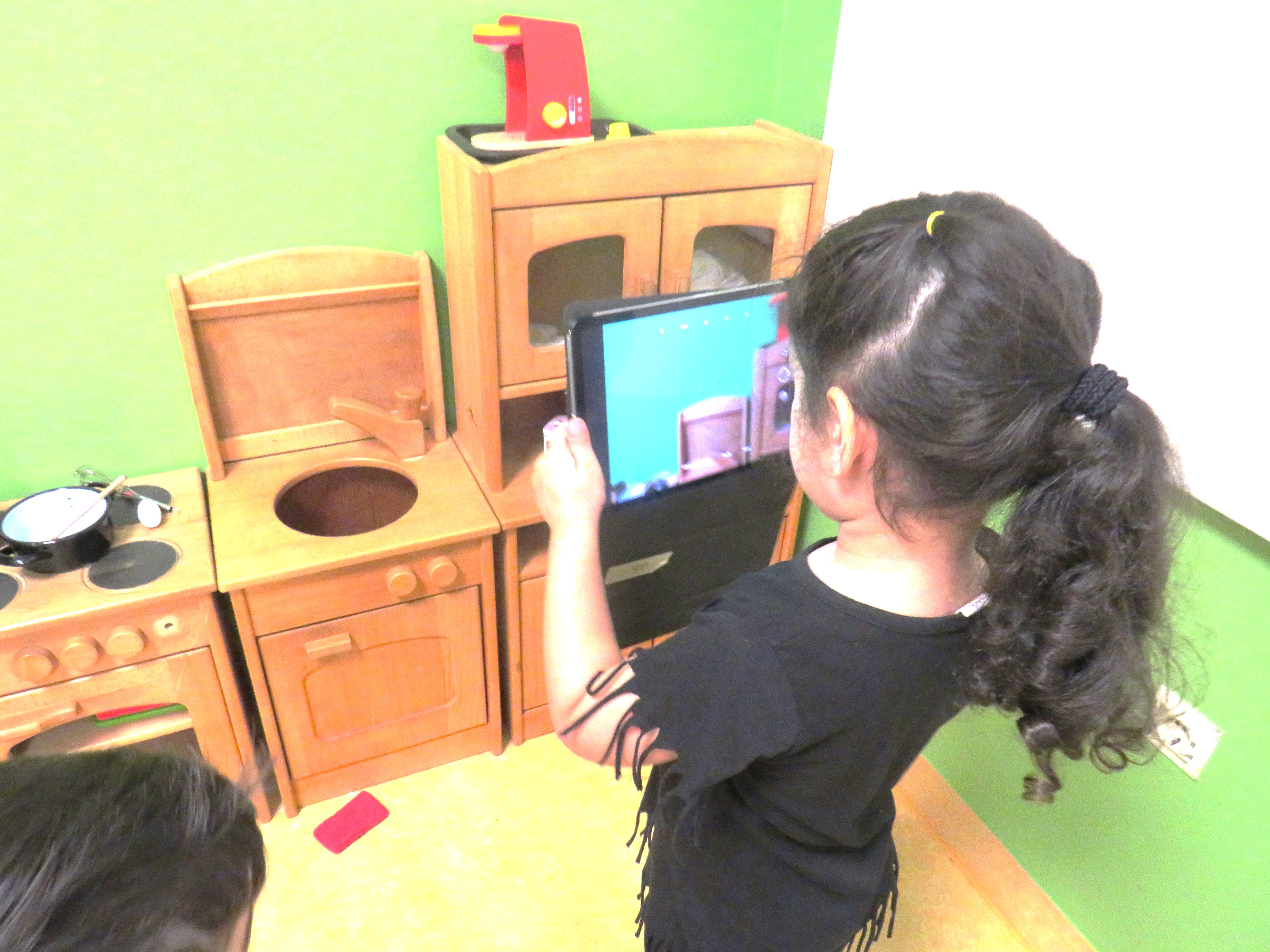 Mit dem Tablet erkunden die Kinder selbstbestimmt ihre Kita-Umgebung. Foto: Kinder in Bewegung gGmbH